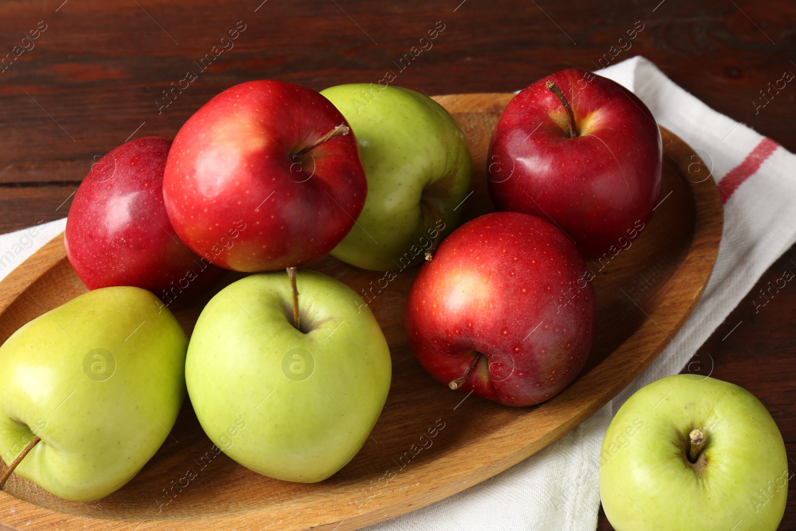 Photo of Fresh red and green apples on wooden table, closeup