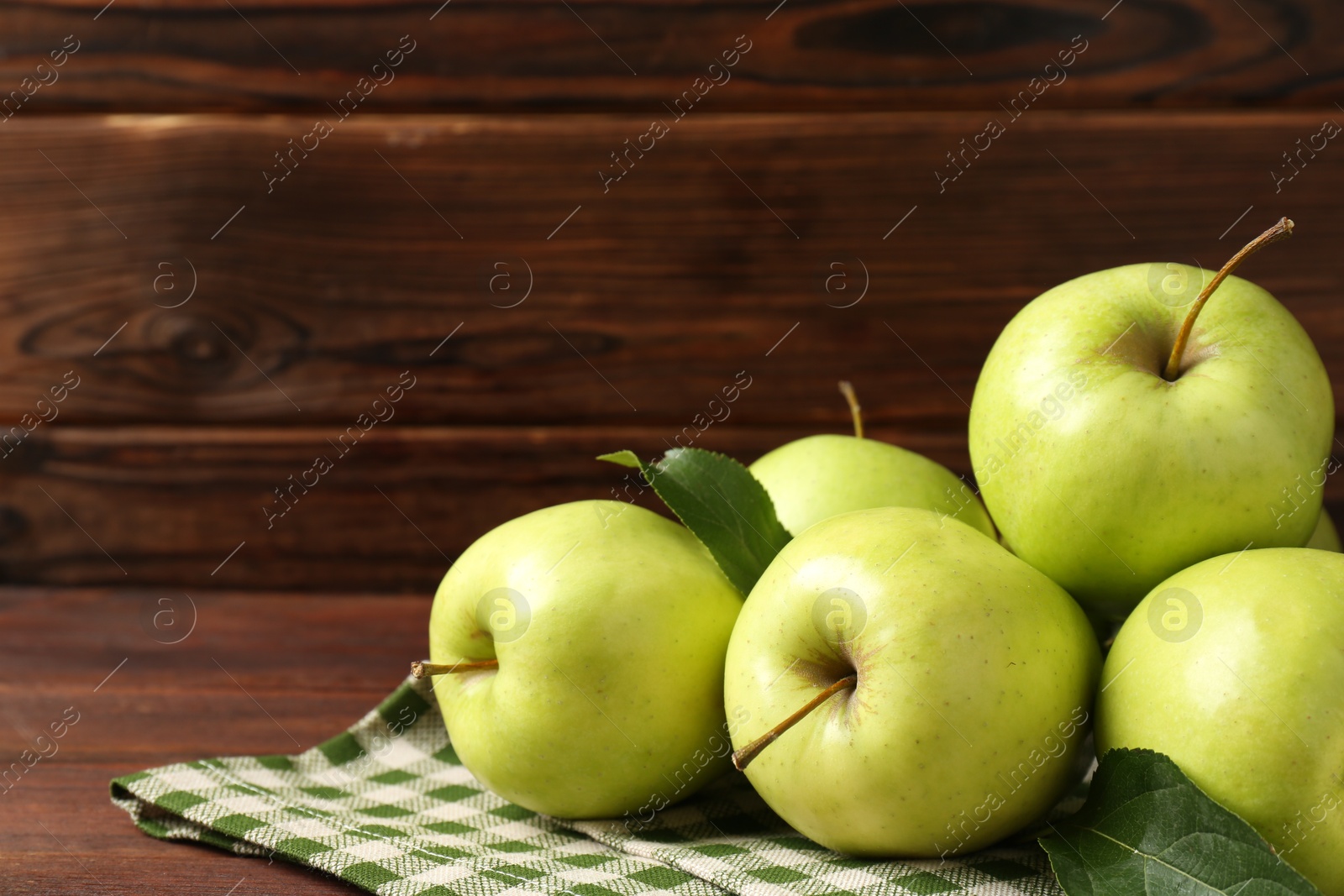 Photo of Fresh green apples on wooden table, space for text