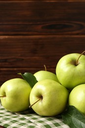 Photo of Fresh green apples on wooden table, closeup. Space for text