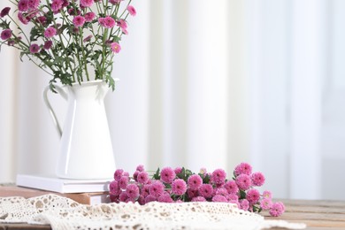 Beautiful chrysanthemum flowers and books on table indoors. Space for text