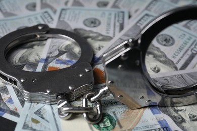 Corruption. Handcuffs on dollar banknotes, closeup view