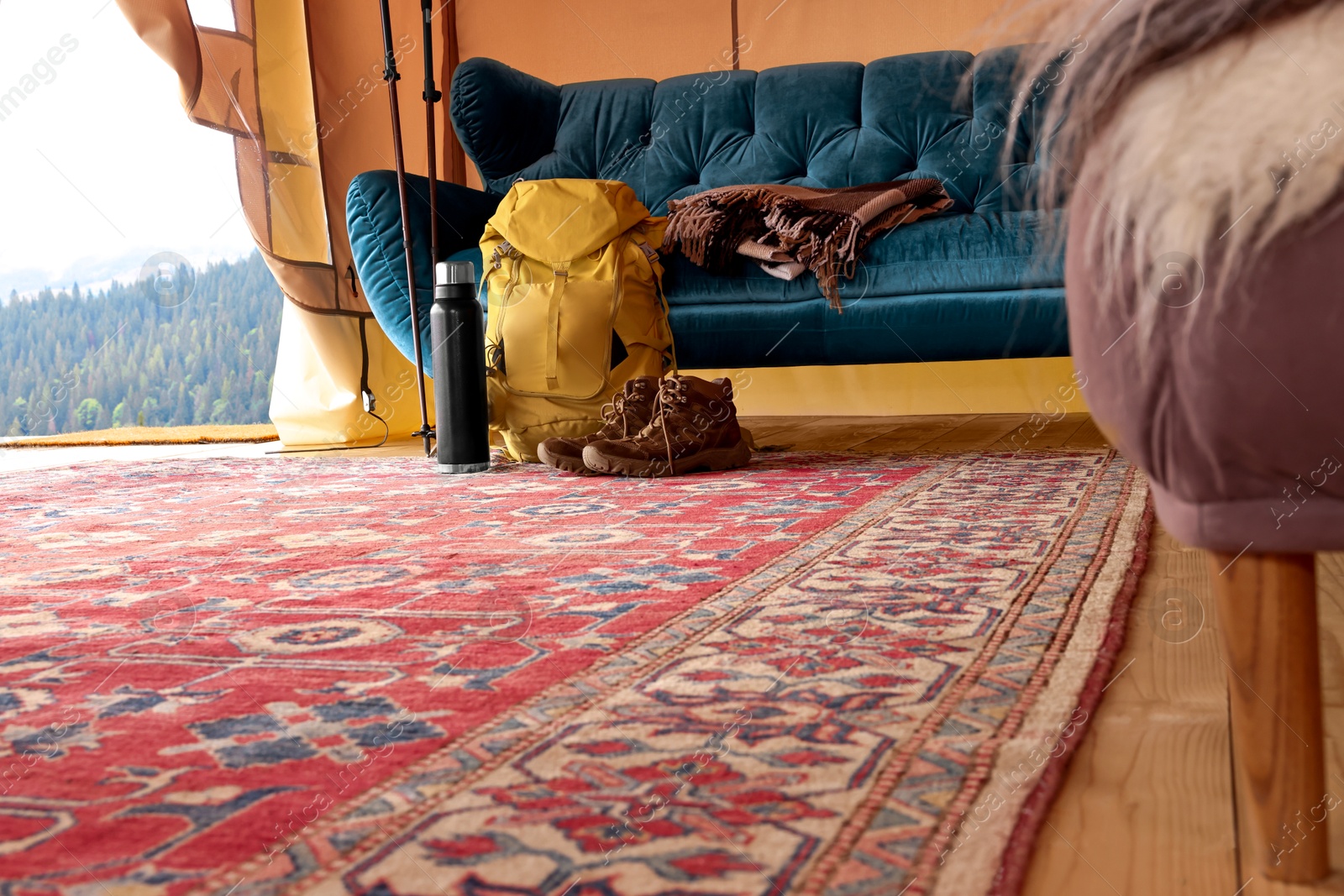 Photo of Comfortable sofa and tourist stuff in glamping site