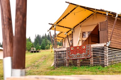 Photo of Tents and green forest in mountains. Glamping site