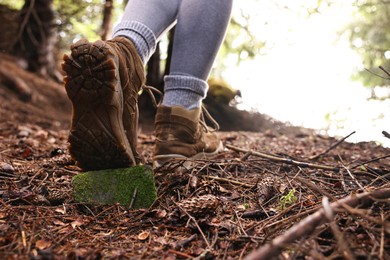 Hiker in trekking shoes walking in forest, closeup