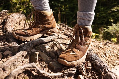 Young hiker wearing trekking shoes outdoors, closeup