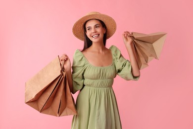 Photo of Smiling woman with shopping bags on pink background