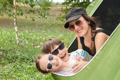 Photo of Mother and her kids resting in camping tent outdoors