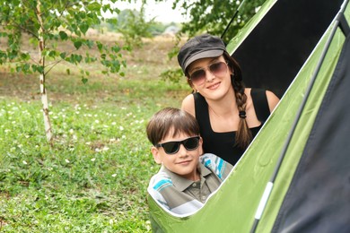 Mother and her son resting in camping tent outdoors