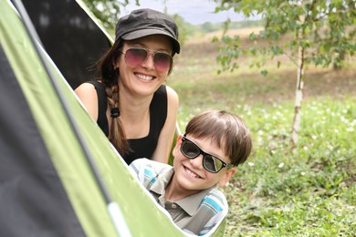 Mother and her son resting in camping tent outdoors