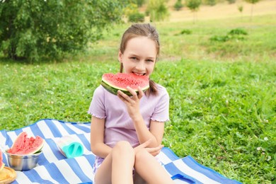 Photo of Girl eating slice of fresh watermelon outdoors