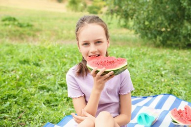 Photo of Girl eating slice of fresh watermelon outdoors