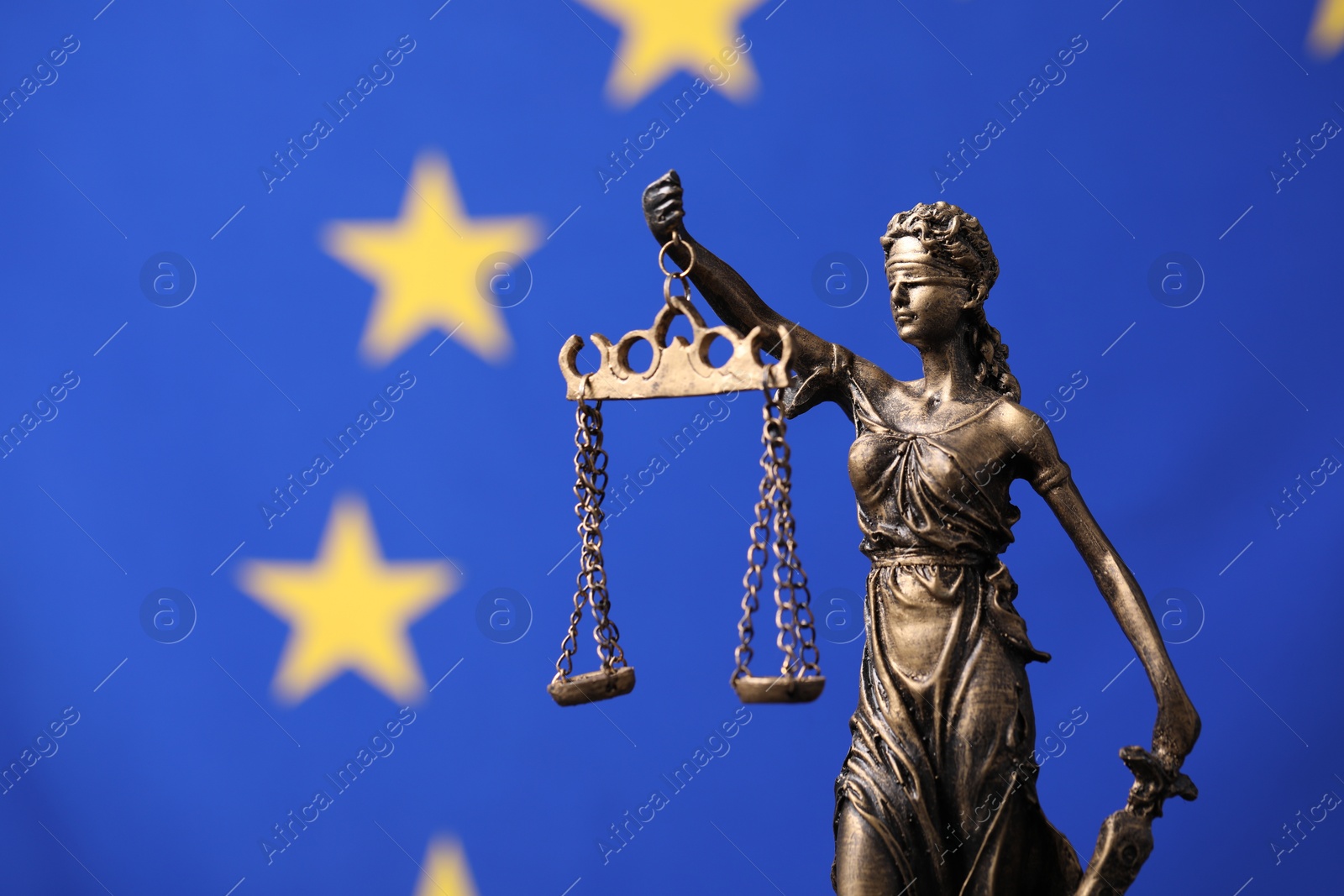 Photo of Figure of Lady Justice against European Union flag. Space for text