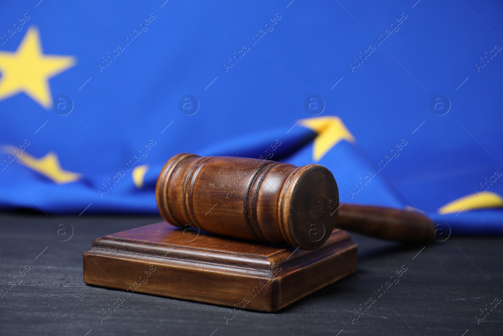 Photo of Judge's gavel on grey table against European Union flag