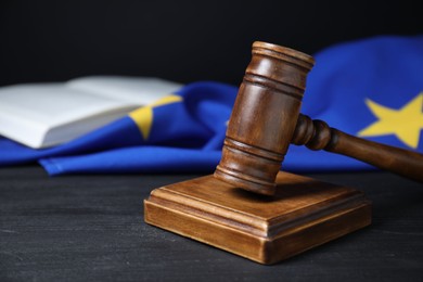 Judge's gavel, book and European Union flag on grey table against black background, closeup. Space for text