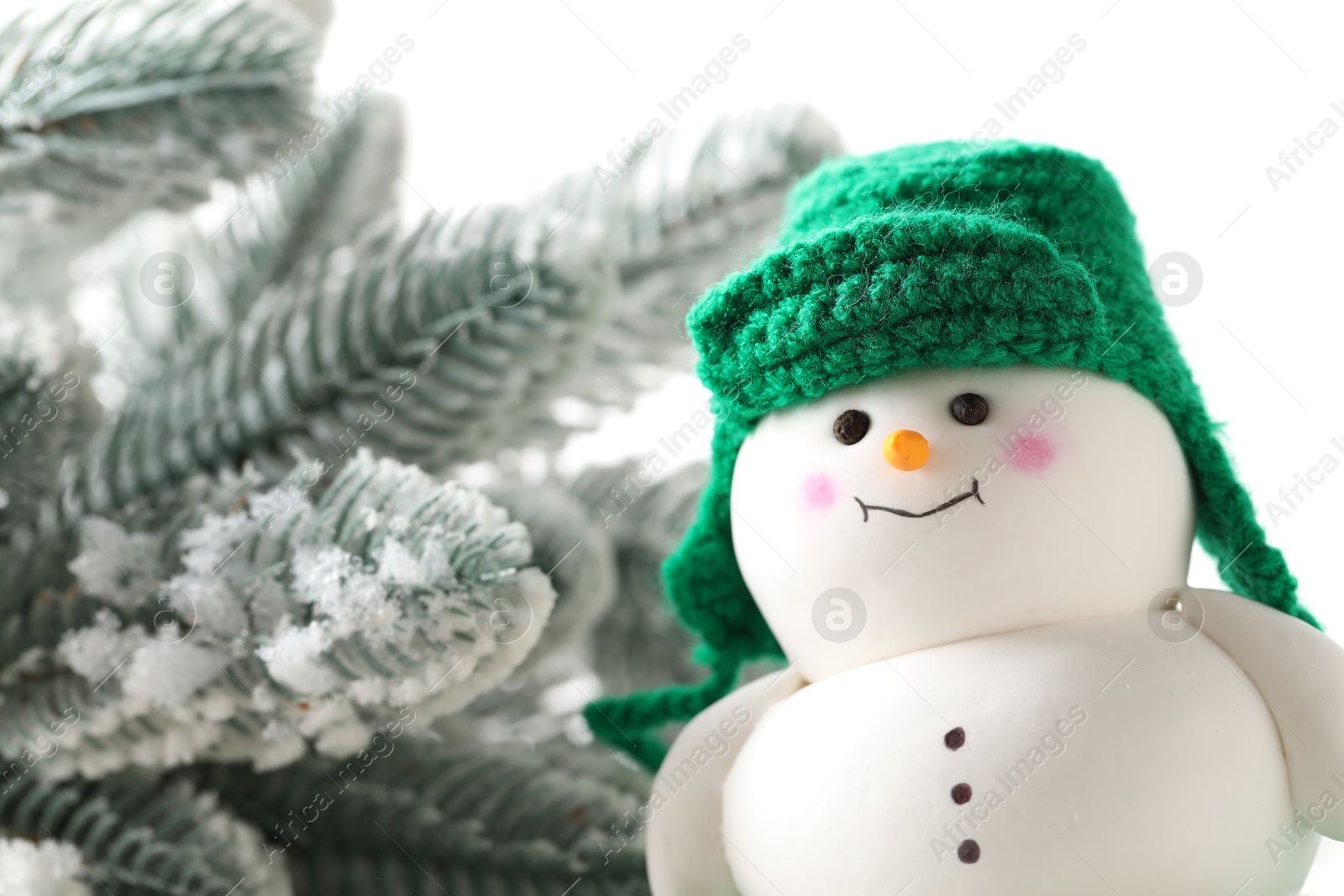 Photo of Cute decorative snowman and fir tree branches against white background, closeup