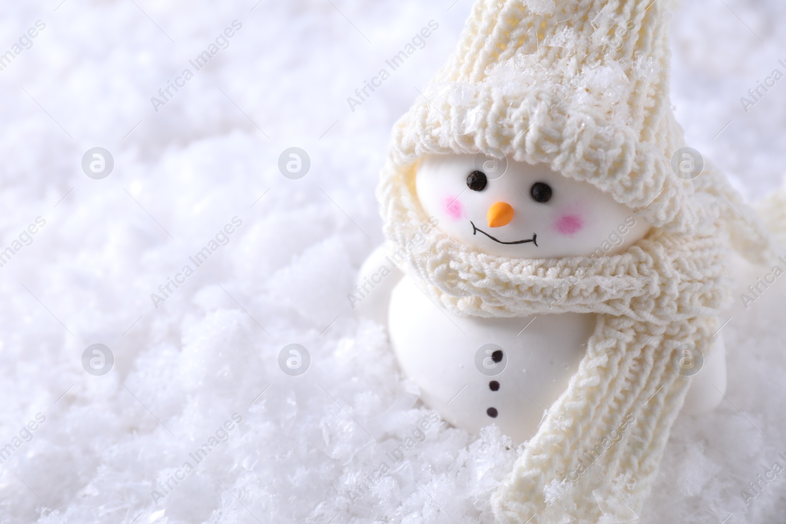 Photo of Cute decorative snowman on artificial snow, closeup. Space for text