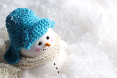 Photo of Cute decorative snowman on artificial snow, closeup. Space for text