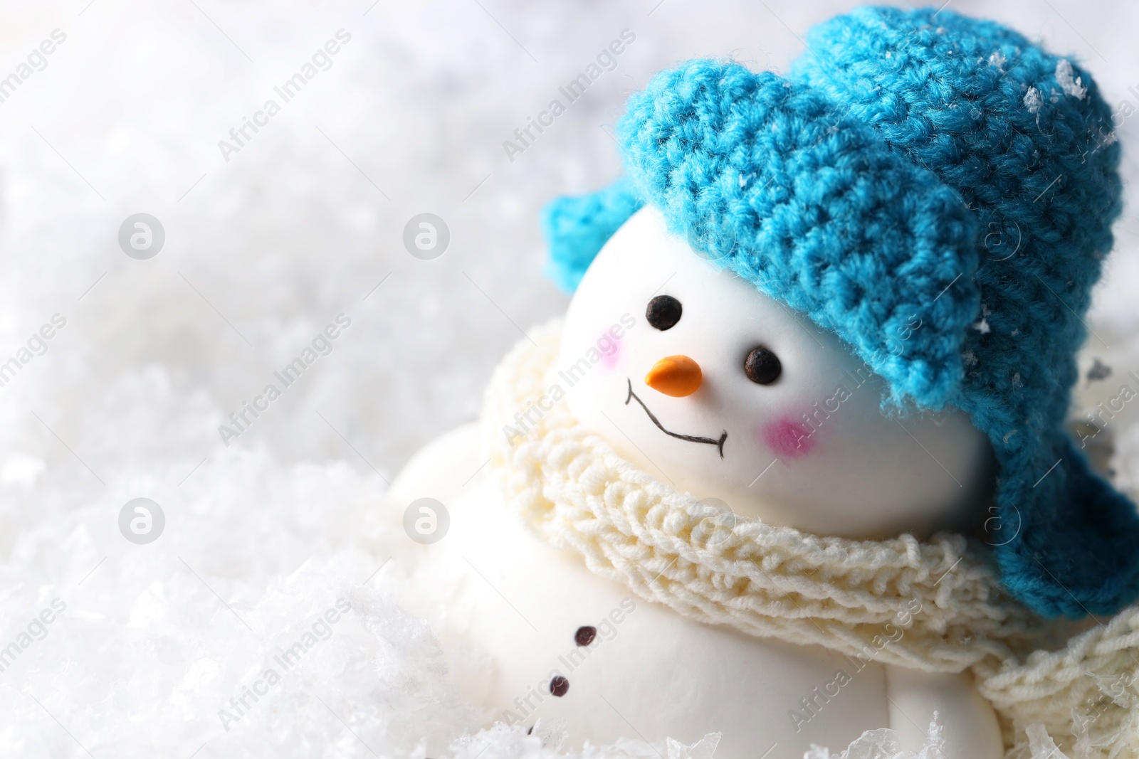 Photo of Cute decorative snowman on artificial snow, closeup. Space for text