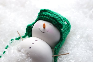 Photo of Cute decorative snowman on artificial snow, closeup