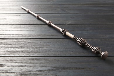 Photo of One old magic wand on wooden table, closeup