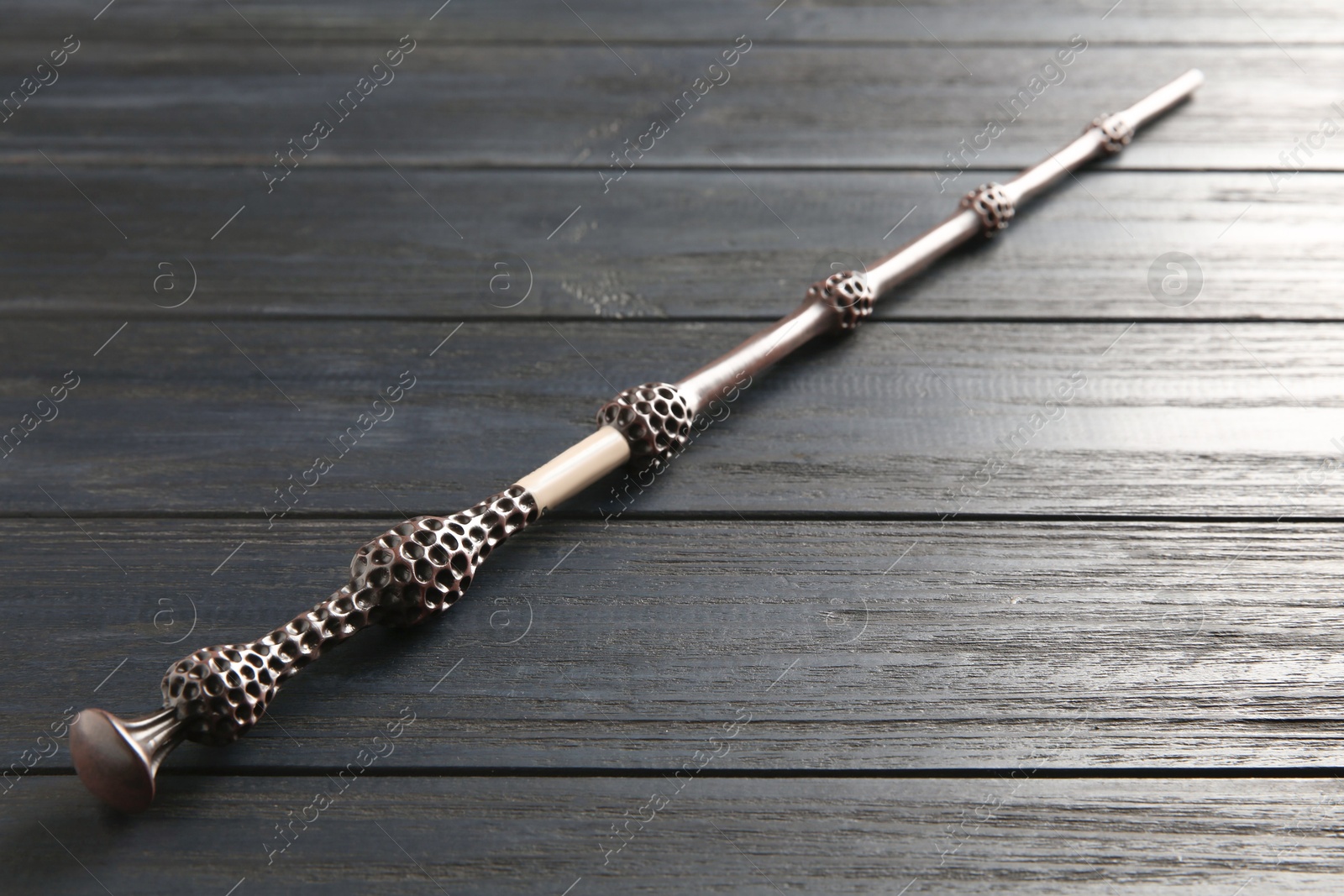 Photo of One old magic wand on wooden table, closeup