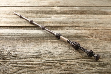 One old magic wand on wooden table, closeup