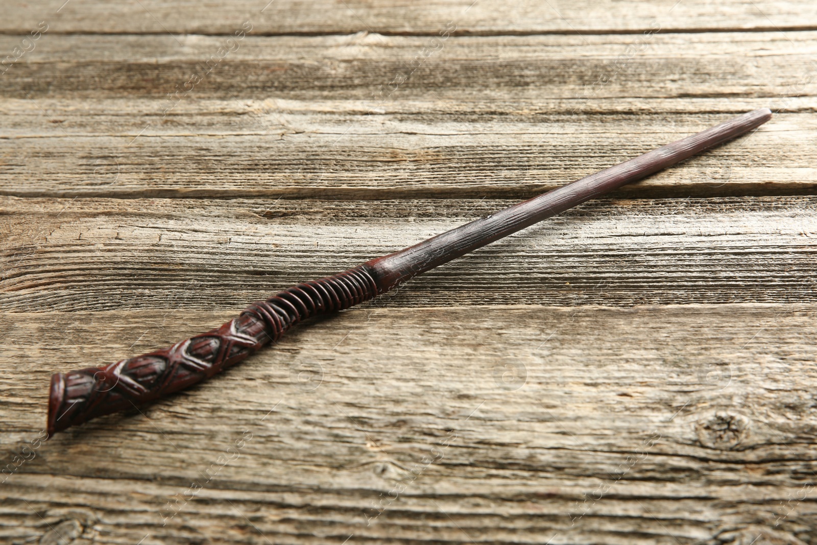 Photo of One old magic wand on wooden table, closeup