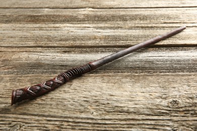 Photo of One old magic wand on wooden table, closeup