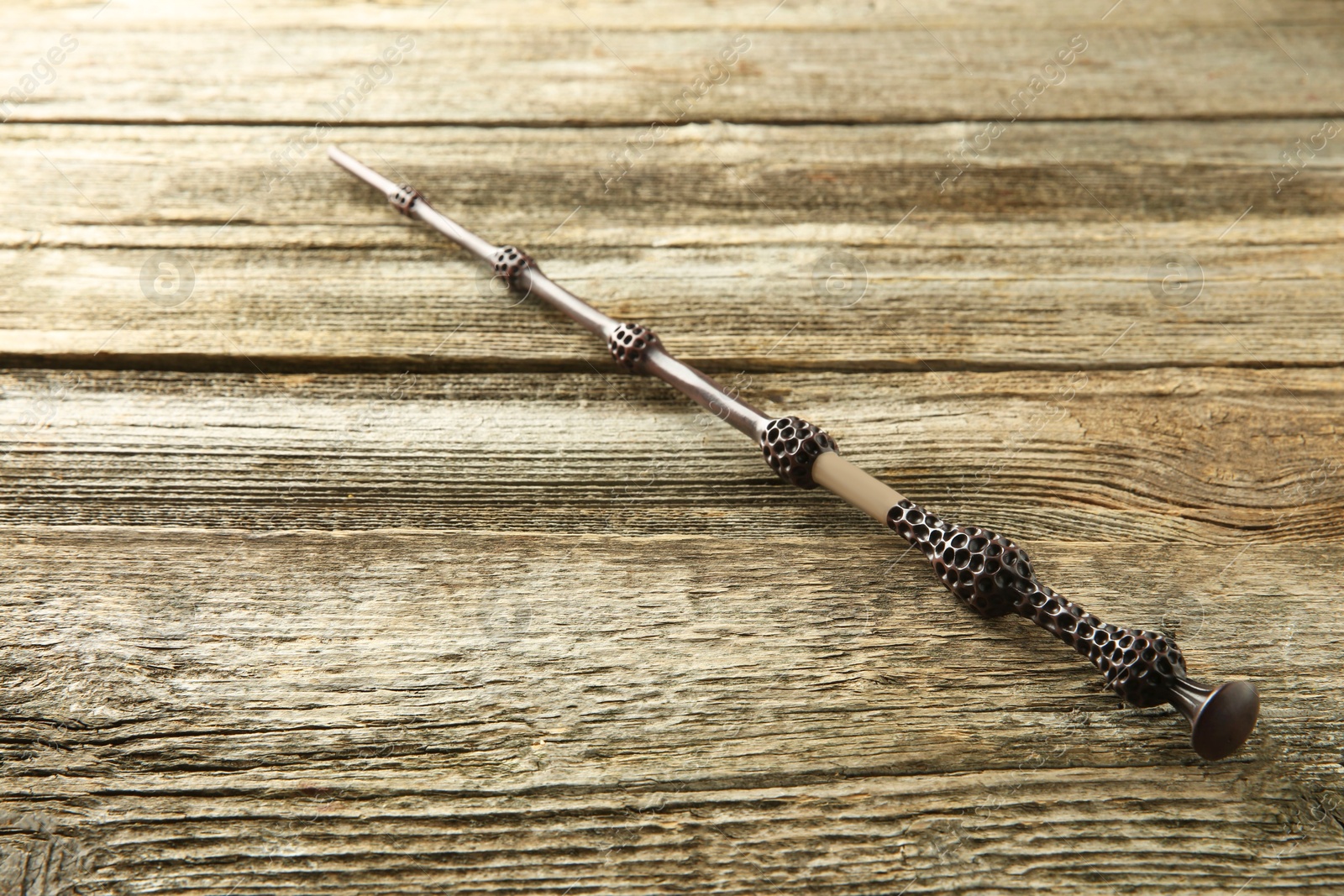 Photo of One magic wand on wooden table, closeup