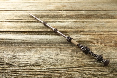 Photo of One magic wand on wooden table, closeup