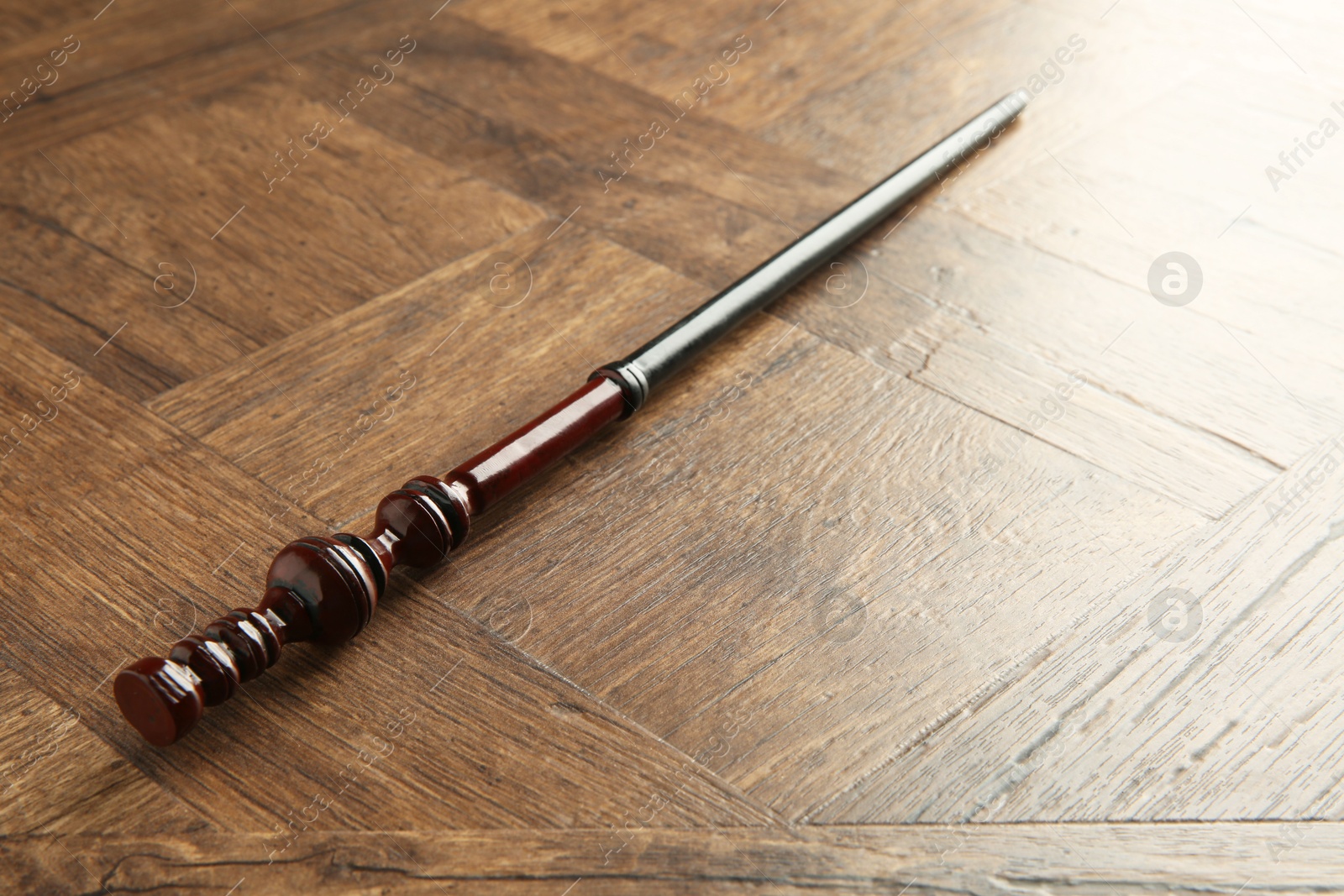 Photo of One magic wand on wooden table, closeup