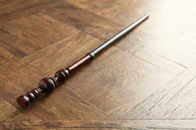 Photo of One magic wand on wooden table, closeup