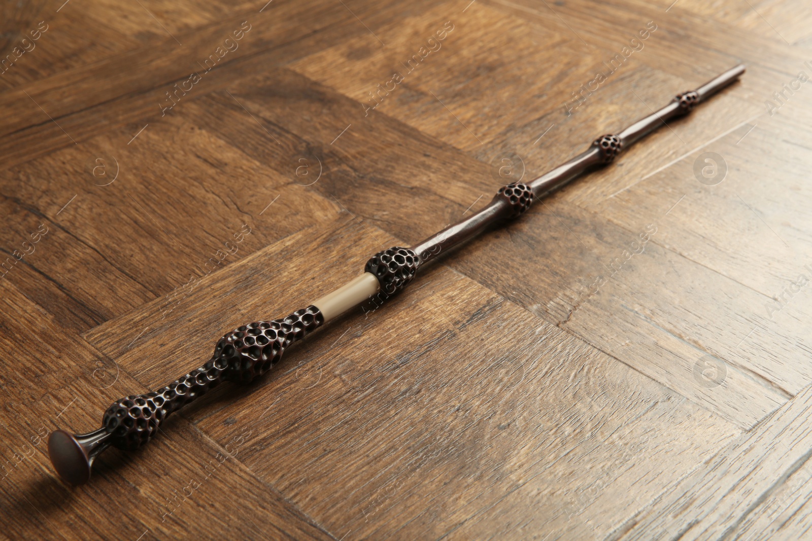 Photo of One magic wand on wooden table, closeup