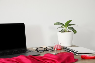 Photo of Laptop and different designer`s supplies on wooden table in workshop