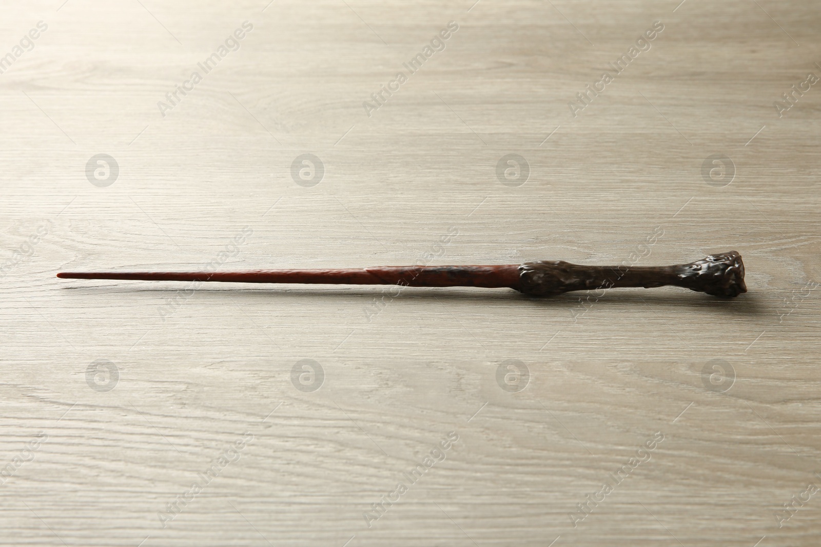 Photo of One magic wand on light wooden table