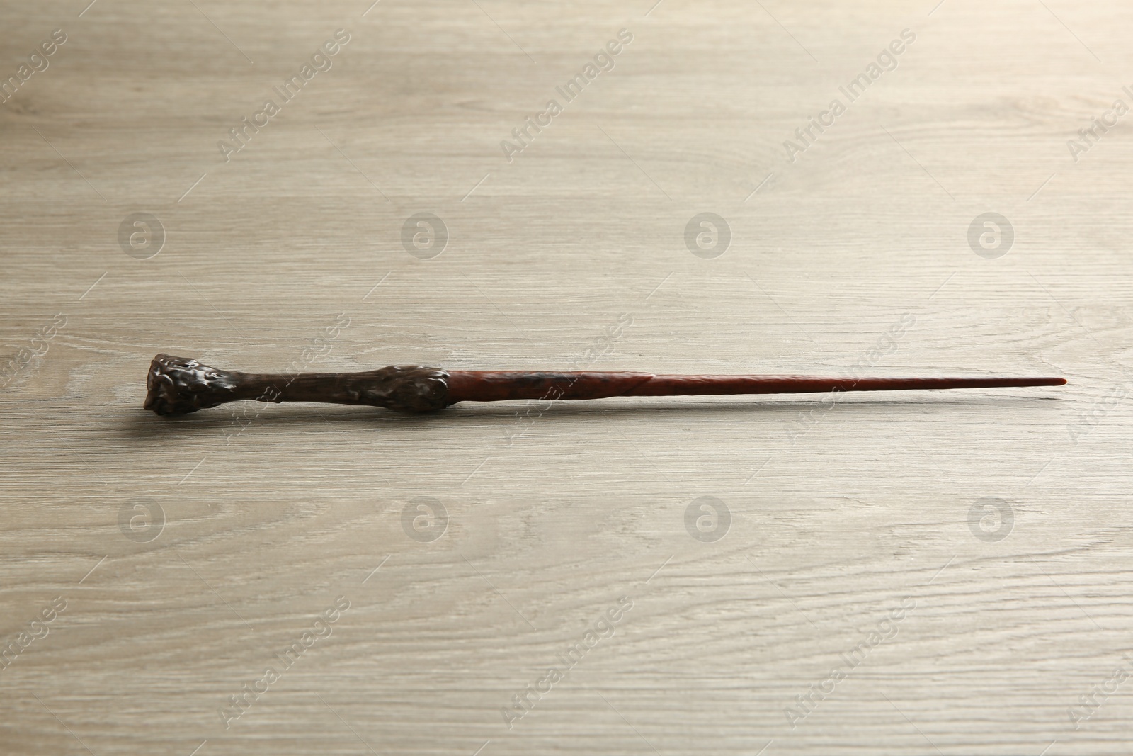 Photo of One magic wand on light wooden table