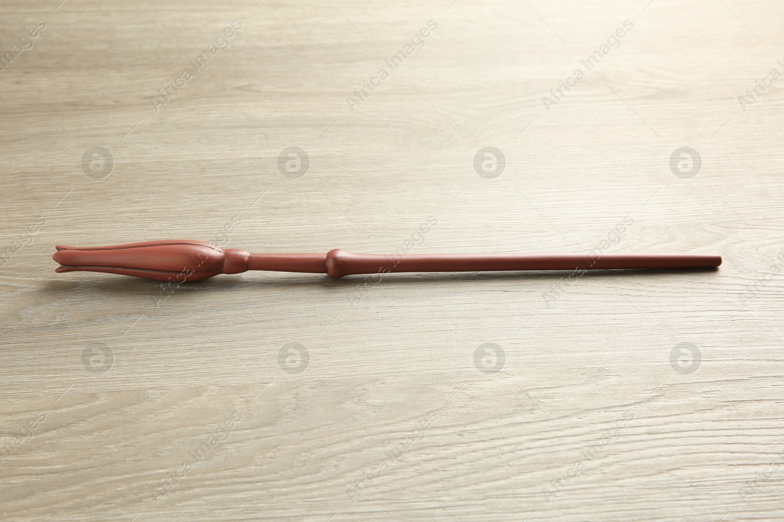 Photo of One magic wand on light wooden table