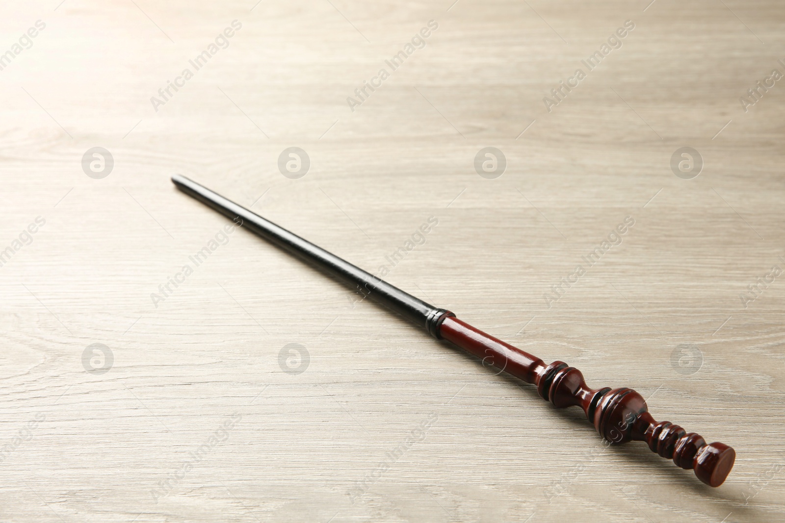 Photo of One magic wand on light wooden table