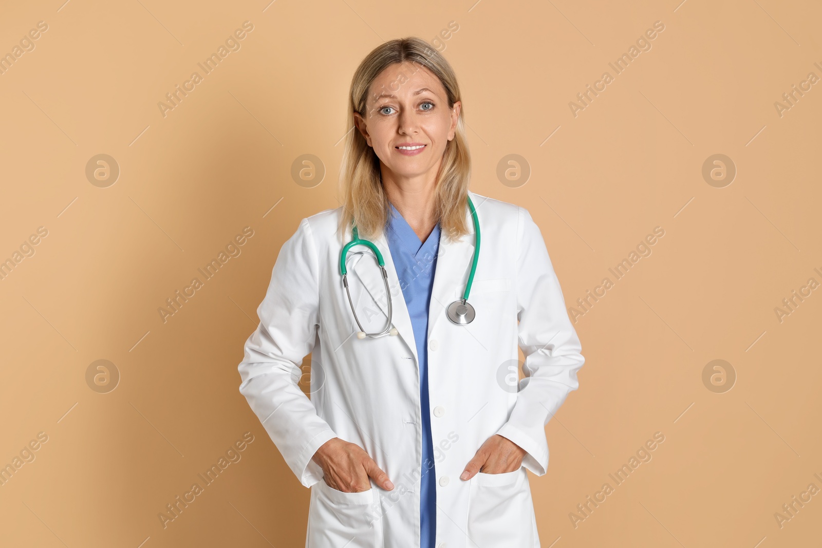 Photo of Portrait of doctor in medical uniform with stethoscope on beige background