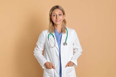 Portrait of doctor in medical uniform with stethoscope on beige background