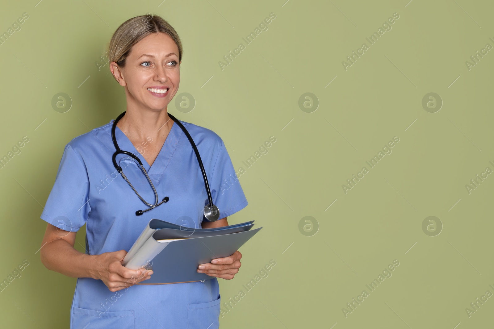 Photo of Nurse in medical uniform with folders on light green background, space for text