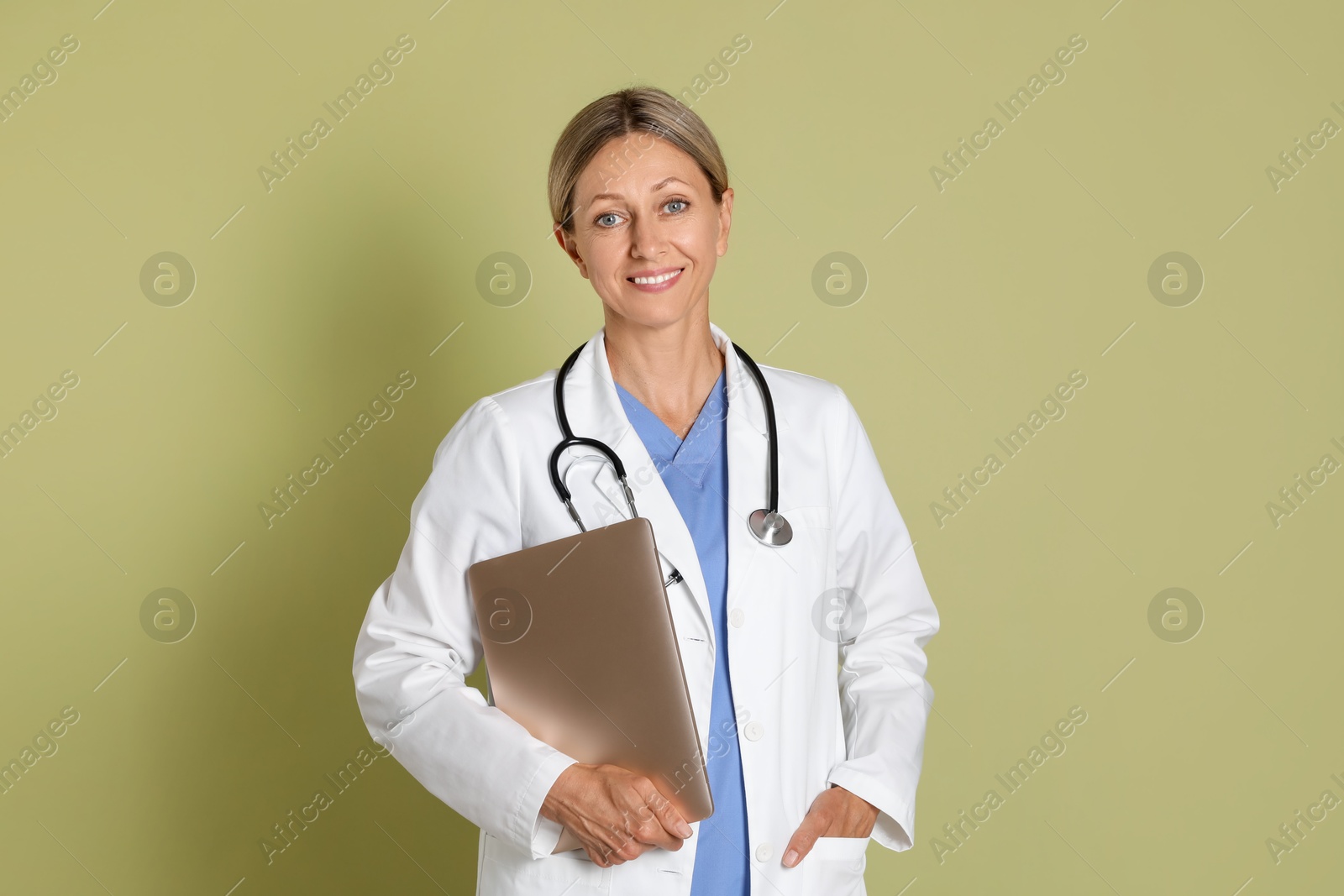 Photo of Doctor in medical uniform with stethoscope and laptop on light green background