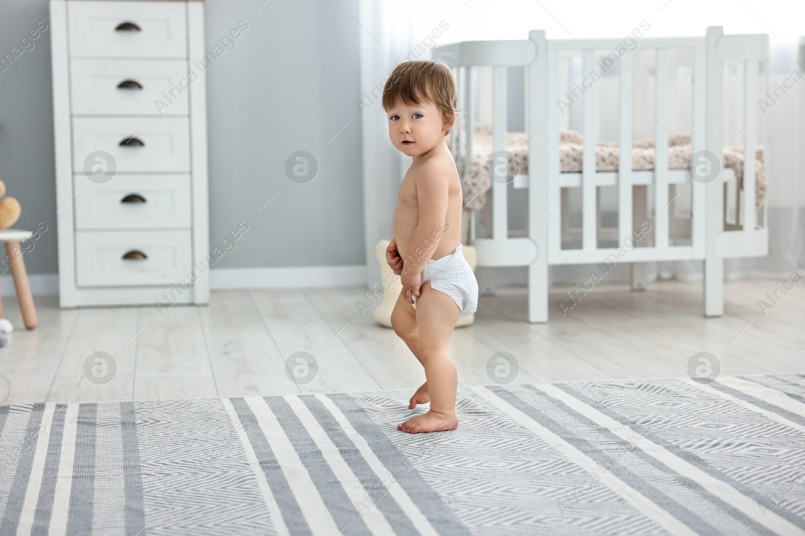 Photo of Cute little child in diaper at home