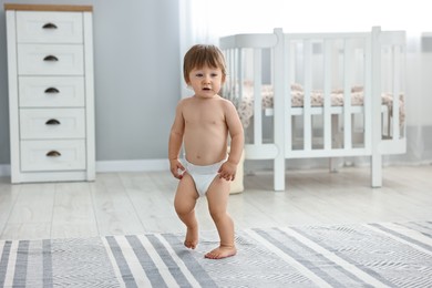 Photo of Cute little child in diaper at home