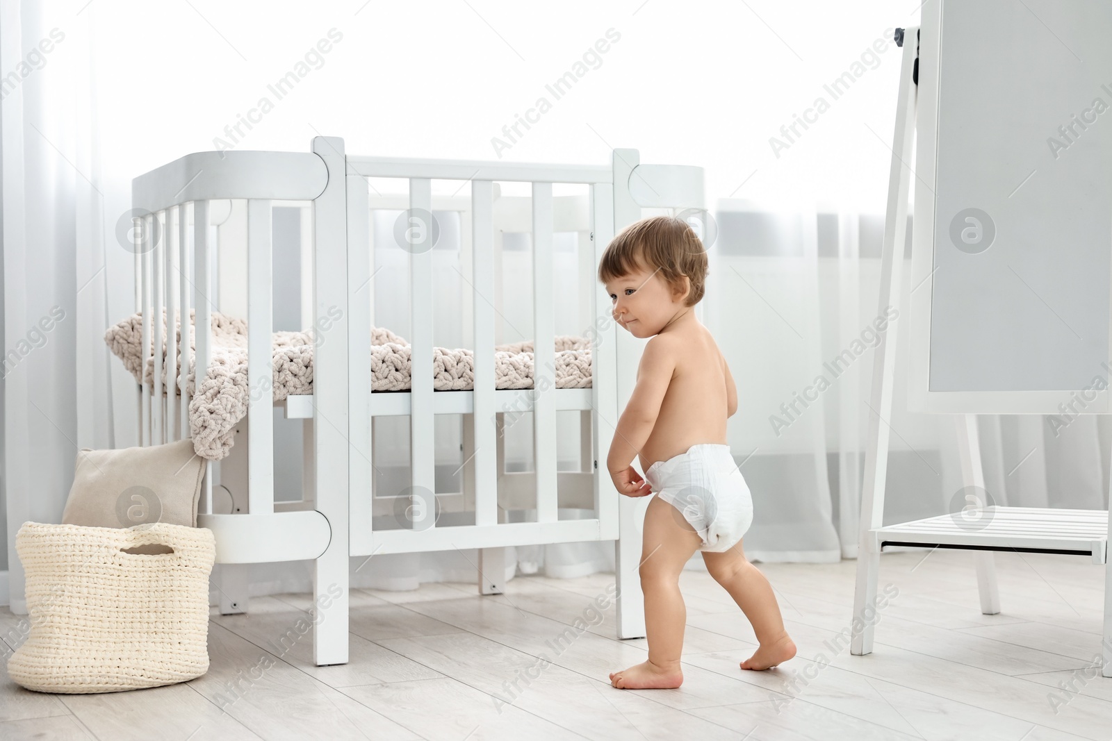 Photo of Cute little child in diaper at home