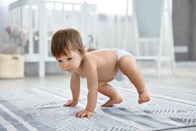 Photo of Cute little child in diaper at home