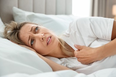 Menopause. Woman suffering from hot flash in bed at home