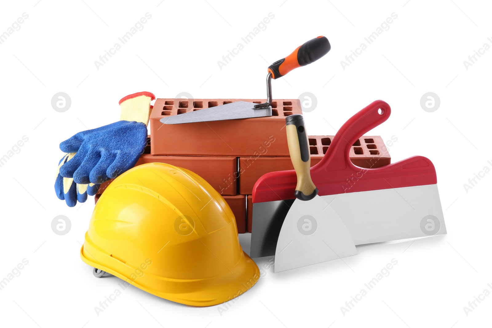 Photo of Yellow hard hat, red bricks, gloves, trowel and putty knives isolated on white. Building material and construction tools