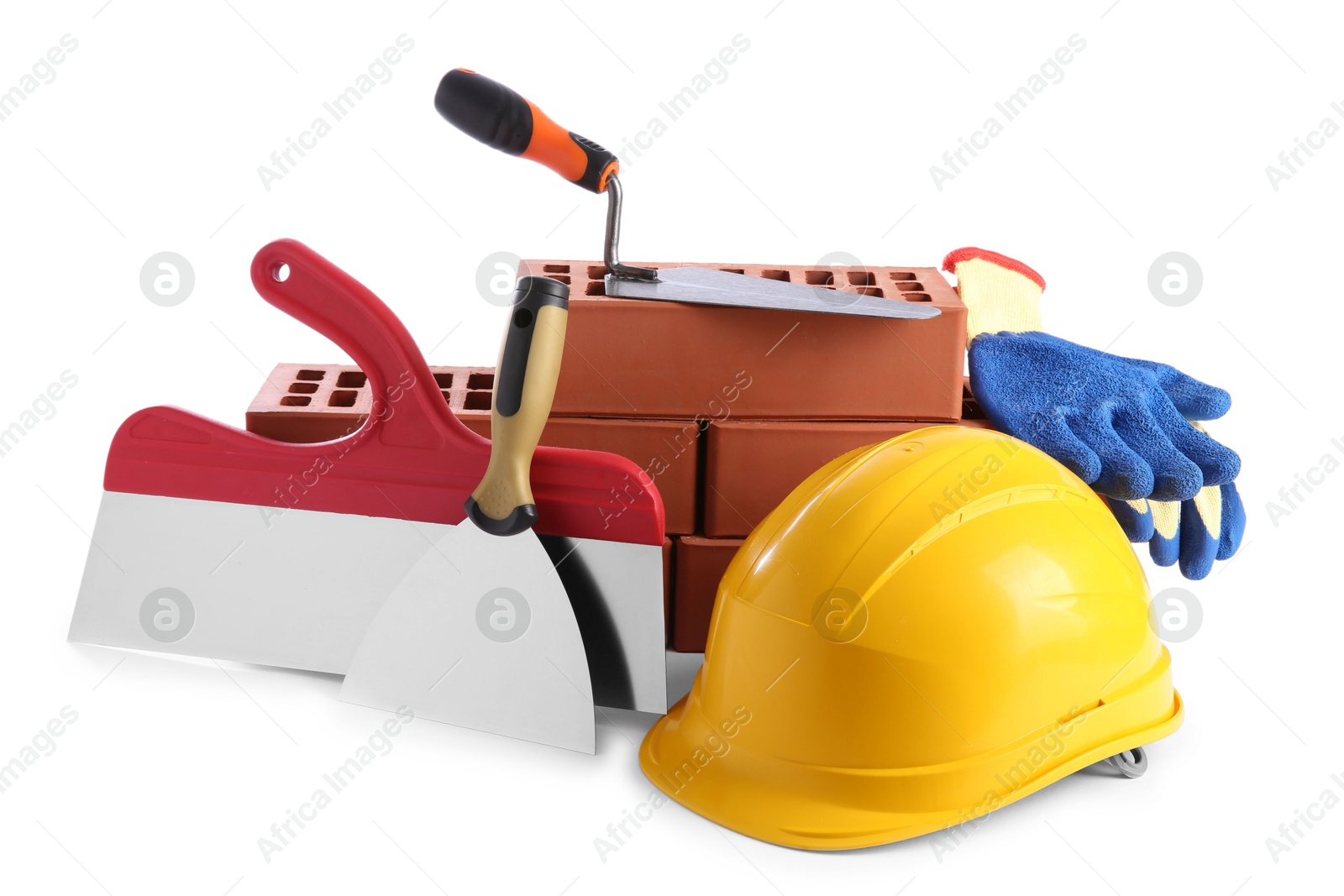 Photo of Yellow hard hat, red bricks, gloves, trowel and putty knives isolated on white. Building material and construction tools