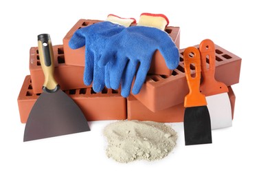 Photo of Putty knives, cement powder, gloves and red bricks isolated on white. Building materials and construction tools